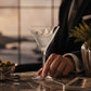 Mellow Monkey Regatta martini glass with sand-etched sailboat design and frosted base held by a man in a suit.