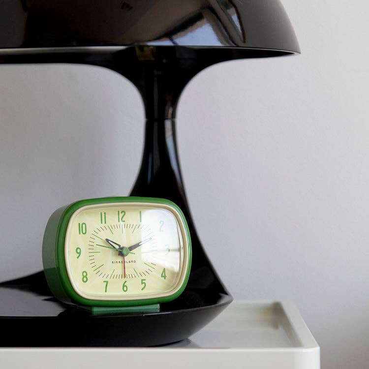 Mellow Monkey Kikkerland retro green desk alarm clock with a glow in the dark face sitting on a black surface