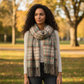 Mellow Monkey Rory plaid fringe scarf in soft brushed acrylic worn by a woman in an autumn park setting