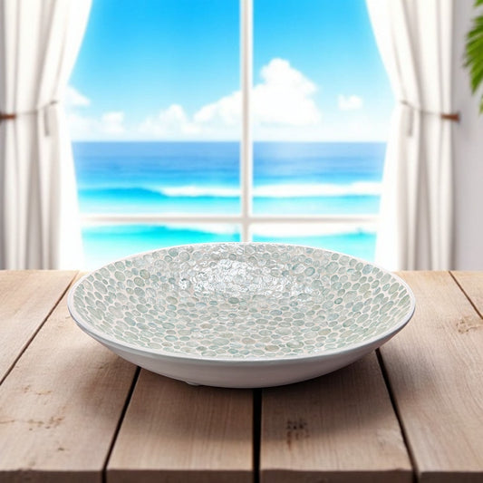 Mellow Monkey 18-inch round bowl crafted from iridescent capiz shells, featuring ball feet on a wooden table.