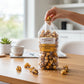 Mellow Monkey gourmet salted chocolate caramel popcorn in a clear bag held by a hand on a wooden table.
