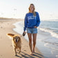 Mellow Monkey Salty Graphic Sweatshirt in heather royal blue with white distressed lettering. Cozy crewneck for casual wear.