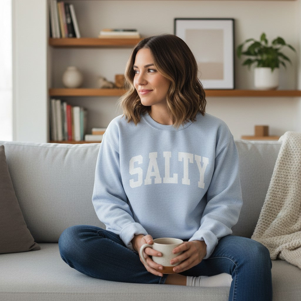 Mellow Monkey light blue crewneck sweatshirt with white "SALTY" graphic, relaxed fit, soft fabric.