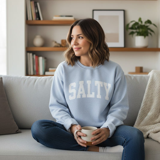 Mellow Monkey light blue crewneck sweatshirt with white "SALTY" graphic, relaxed fit, soft fabric.