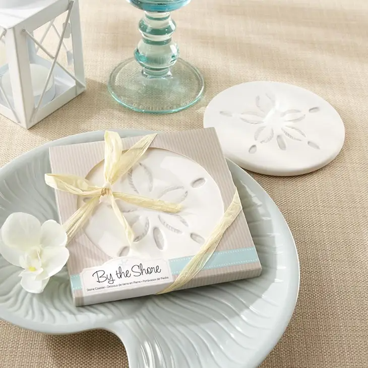 Mellow Monkey sand dollar stone coaster in a gift box with raffia ribbon, perfect for coastal wedding favors.