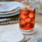 Mellow Monkey set of four white sandstone coasters with sand dollar design under a glass of iced tea