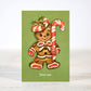 Mellow Monkey sarcastic Christmas card featuring a gingerbread man holding a candy cane on a green background