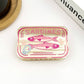 Mellow Monkey sardine can hair claw clip in translucent cream with pink fish graphic and pull tab detail