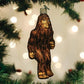 Mellow Monkey Sasquatch blown glass holiday ornament, brown with glitter accents, hanging on a Christmas tree.