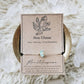 Mellow Monkey Sea Glass crystal wish bracelet on tan hemp cord with gold beads, displayed on a kraft paper card.