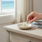Mellow Monkey blue and gold sea life earrings trio featuring starfish and seashell designs on a small ceramic dish.