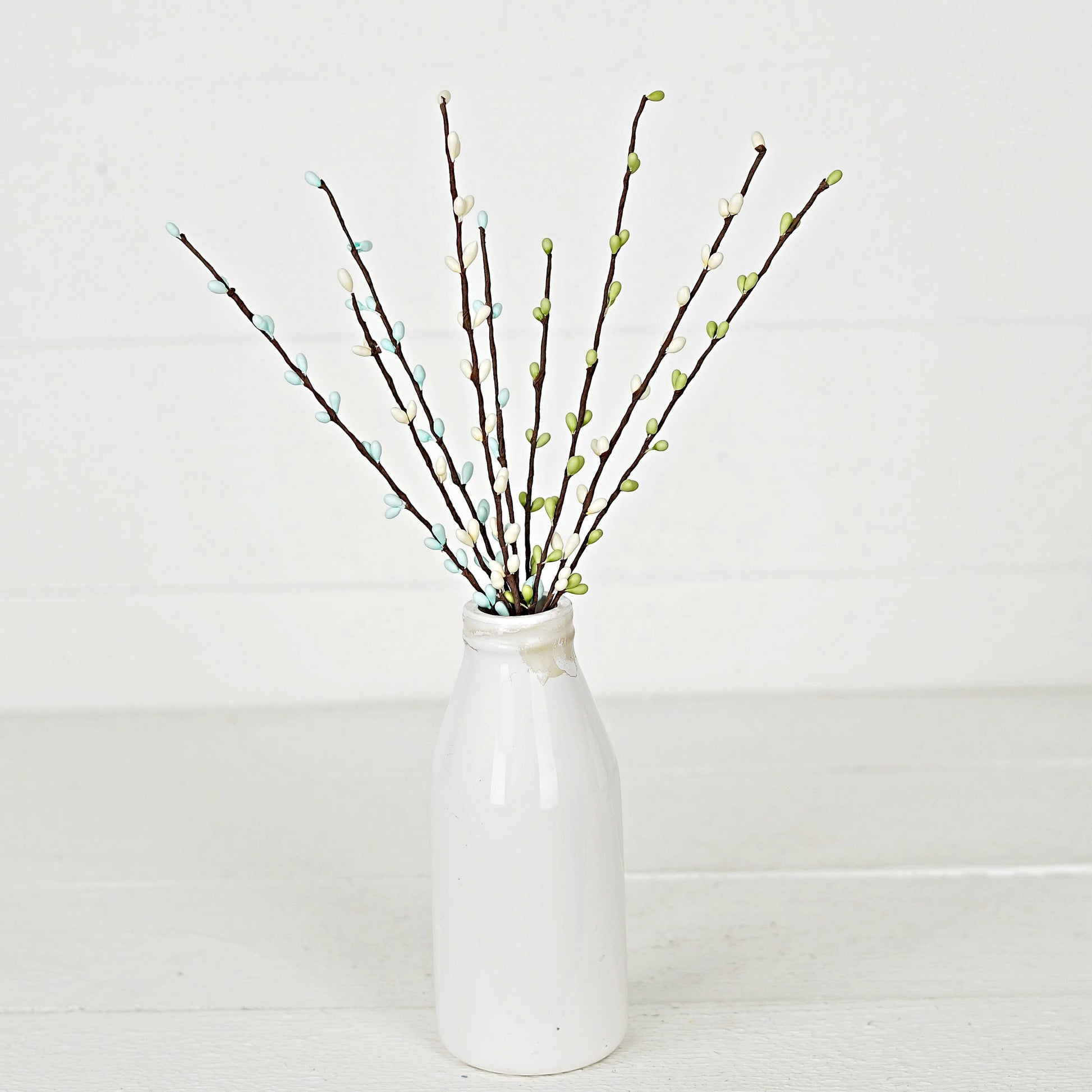 Mellow Monkey 12-inch Seabreeze pip berry pick with blue, green, and white berries on brown stems in a white vase.