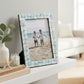 Mellow Monkey seafoam mother of pearl tile photo frame on a white shelf with a beach photo in portrait orientation
