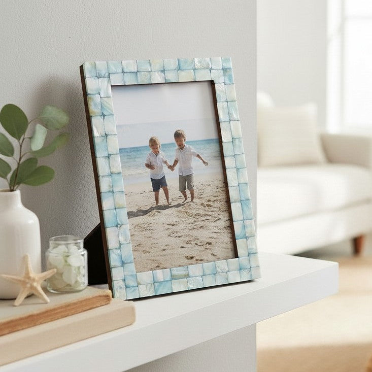 Mellow Monkey seafoam mother of pearl tile photo frame on a white shelf with a beach photo in portrait orientation
