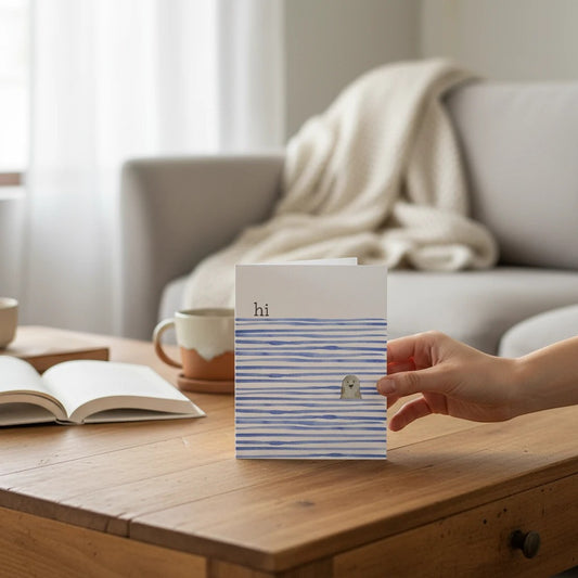 Mellow Monkey Coastal Seal greeting card with "hi" text and a cute seal illustration on blue striped water.