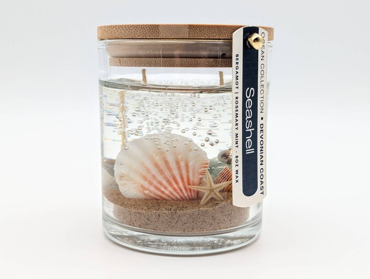 Mellow Monkey Sea Shell Beach Treasure gel candle with seashells, sand, and a wooden lid in a glass jar.