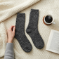 Mellow Monkey Shadow ragg wool crew socks in charcoal grey, resting on a cozy cream knit blanket with coffee and book.
