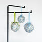 Mellow Monkey Kim Hovell Shell Trio decoupage baubles with blue and green abstract art hanging on a black stand