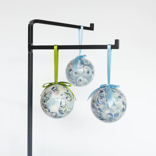 Mellow Monkey Kim Hovell Shell Trio decoupage baubles with blue and green abstract art hanging on a black stand