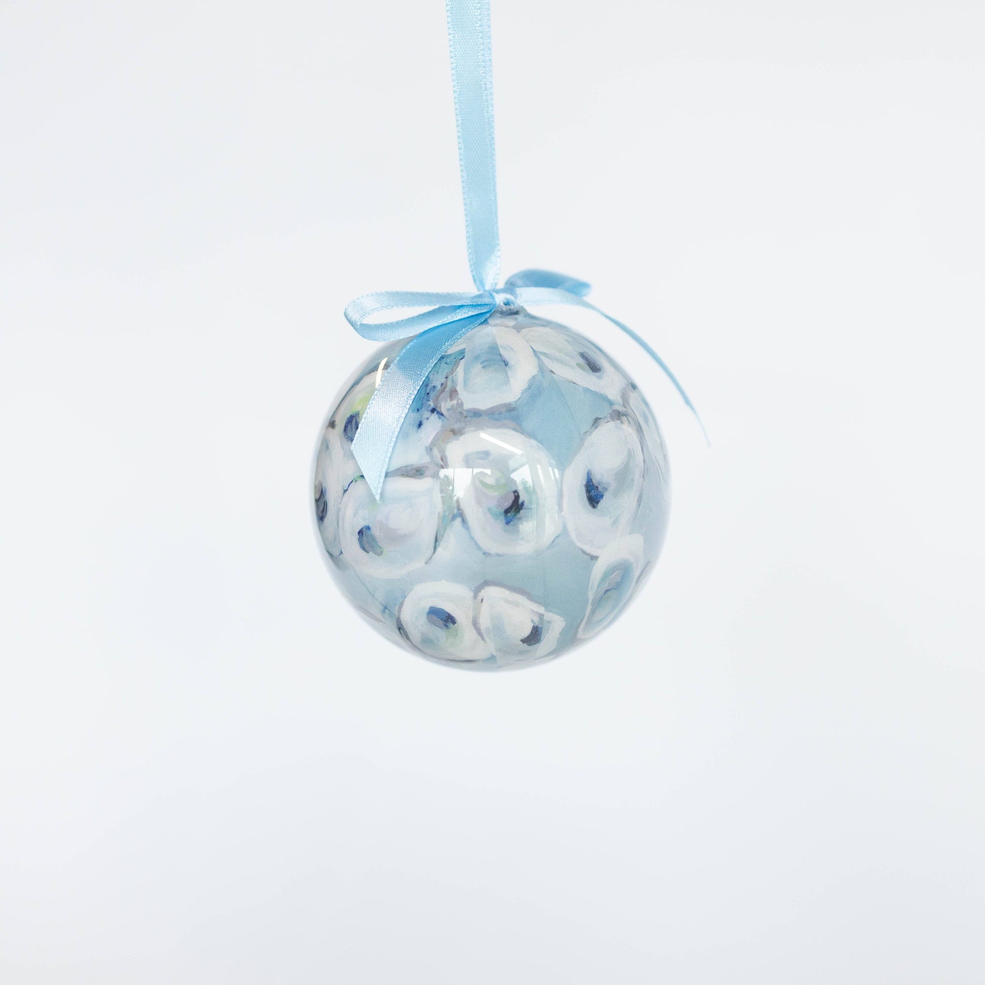Mellow Monkey decoupage glass ornament featuring a blue and white shell pattern with a matching light blue ribbon.