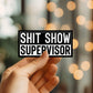 Mellow Monkey Shit Show Supervisor vinyl decal sticker with bold black and white typography held in a hand.
