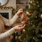 Mellow Monkey Silly Christmas Squirrel ornament, hand-blown glass, wearing a diaper and holding a gift.