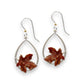 Mellow Monkey silver hoop earrings featuring detailed brown autumn leaf charms on hypoallergenic surgical steel wires.