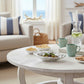 Mellow Monkey Beatriz Ball silver oyster bowl with olives and rosemary on a white coffee table.