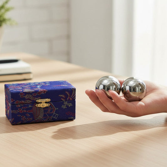 Mellow Monkey Silver Therapy Balls with ornate blue storage box. Shiny spheres for stress relief and hand exercise.