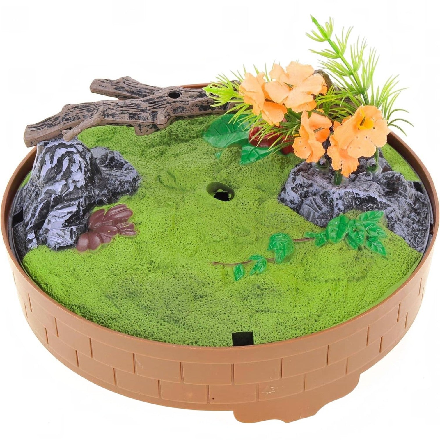 Mellow Monkey motion-activated singing bird base with green grass, faux rocks, a branch, and orange flowers.