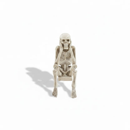 Mellow Monkey resin skeleton shelf sitter in a weathered bone finish, posing with hands covering ears.