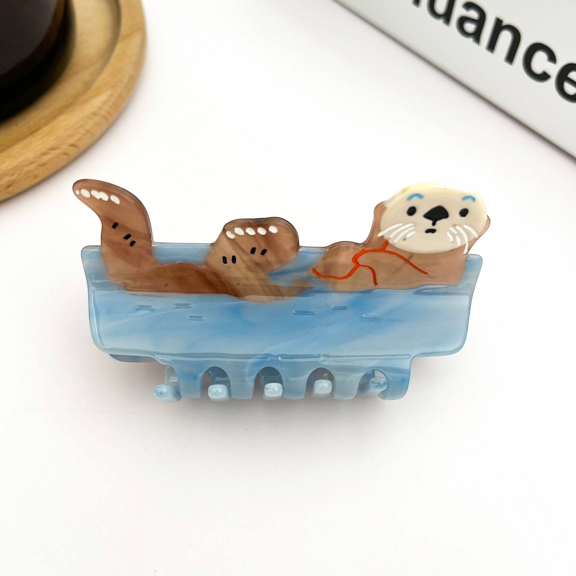 Mellow Monkey blue sleeping otter hair claw clip with a cute brown otter resting in water