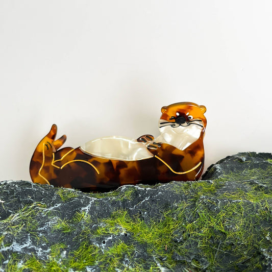 Mellow Monkey brown tortoiseshell sleeping otter hair claw clip resting on a mossy rock