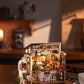 Mellow Monkey Slow Life Café DIY miniature house kit with warm interior lighting and detailed bistro furniture.
