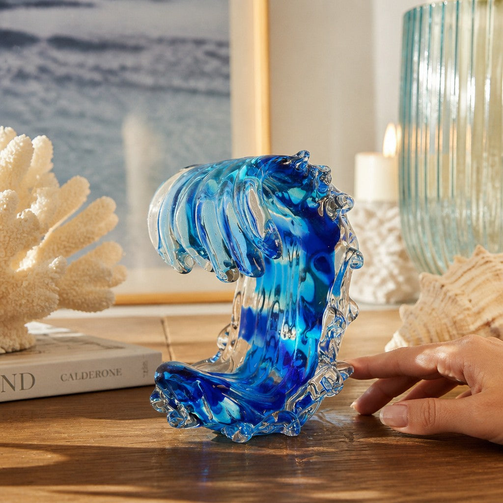 Mellow Monkey Small Sized Wave glass sculpture featuring swirling blue and clear ocean wave design on a wooden table.