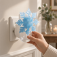 Mellow Monkey snowflake fragrance warmer in icy blue with shimmer, plugged into a wall outlet for home scenting.