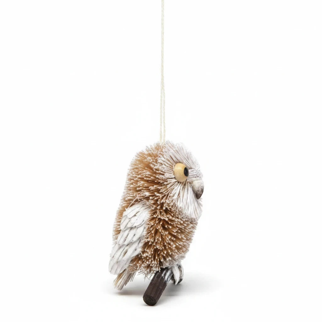 Mellow Monkey 4-inch snowy owl Christmas ornament made from natural brush fibers, pine, and seeds on a branch.