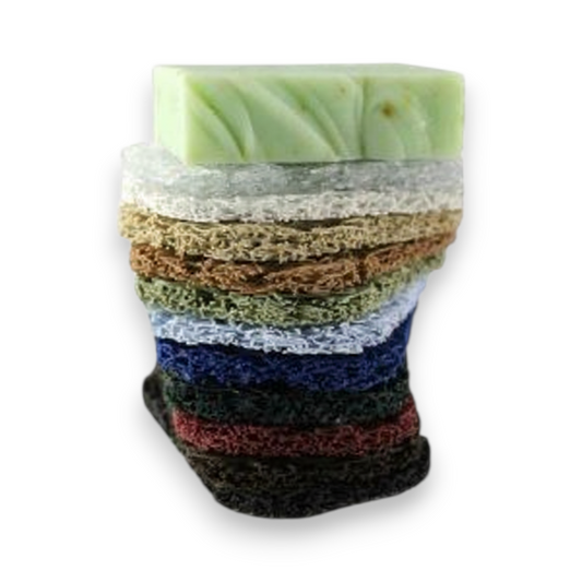 Mellow Monkey Soap Lift multi-directional bioplastic soap saver pads in a variety of colors stacked with bar soap.