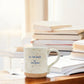 Mellow Monkey ceramic mug with speckled finish and Call Your Mother quote on a desk with books
