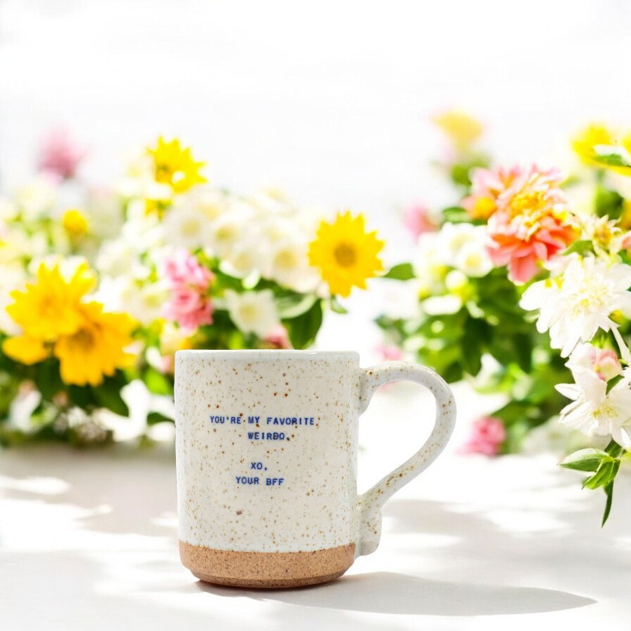 Mellow Monkey handmade ceramic mug with speckles and You're My Favorite Weirdo quote, set against colorful flowers.