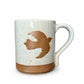 Mellow Monkey speckled stoneware mug featuring a hand-carved brown bird design on a cream background