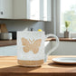 Mellow Monkey speckled stoneware mug featuring a hand-carved butterfly design on a kitchen table.