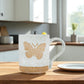 Mellow Monkey speckled stoneware mug featuring a hand-carved butterfly design on a kitchen table.
