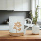 Mellow Monkey speckled stoneware mug featuring a hand-carved flower design on a wooden kitchen table