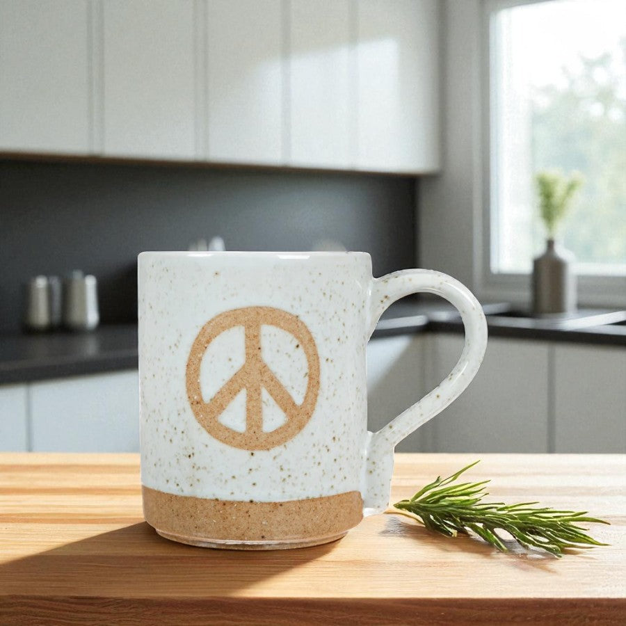 Mellow Monkey speckled stoneware mug featuring a hand-carved peace sign on a wooden kitchen counter