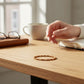 Mellow Monkey spice-colored seed bead bracelet with 18K gold plated brass accents on a wooden desk