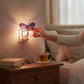 Mellow Monkey pink and purple stained glass butterfly nightlight plugged into a bedroom wall outlet