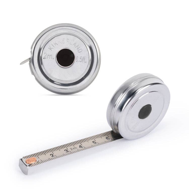 Mellow Monkey mini stainless steel retractable tape measure showing both inches and centimeters on a white background