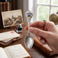 Mellow Monkey silver-tone Stamford Connecticut souvenir spoon with a colorful emblem held in a hand over a desk.