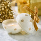 Mellow Monkey star-studded ornament candle in white glass with gold stars and a velvet ribbon on a marble surface